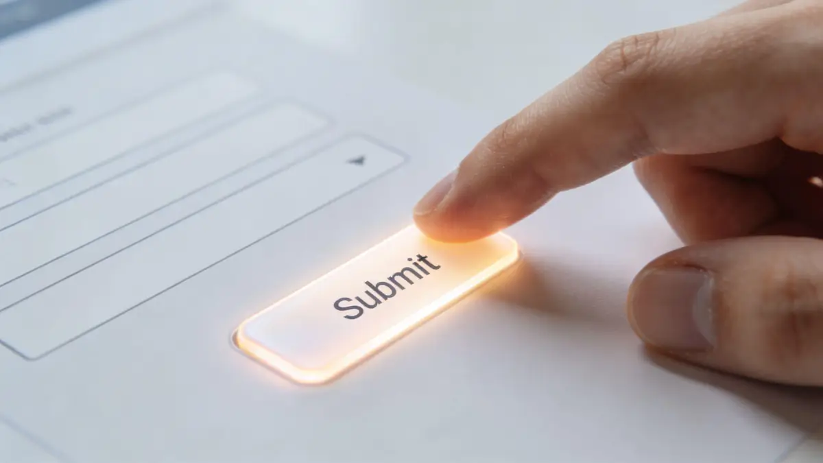A close-up view of a person's finger pressing a glowing submit button on a digital form.