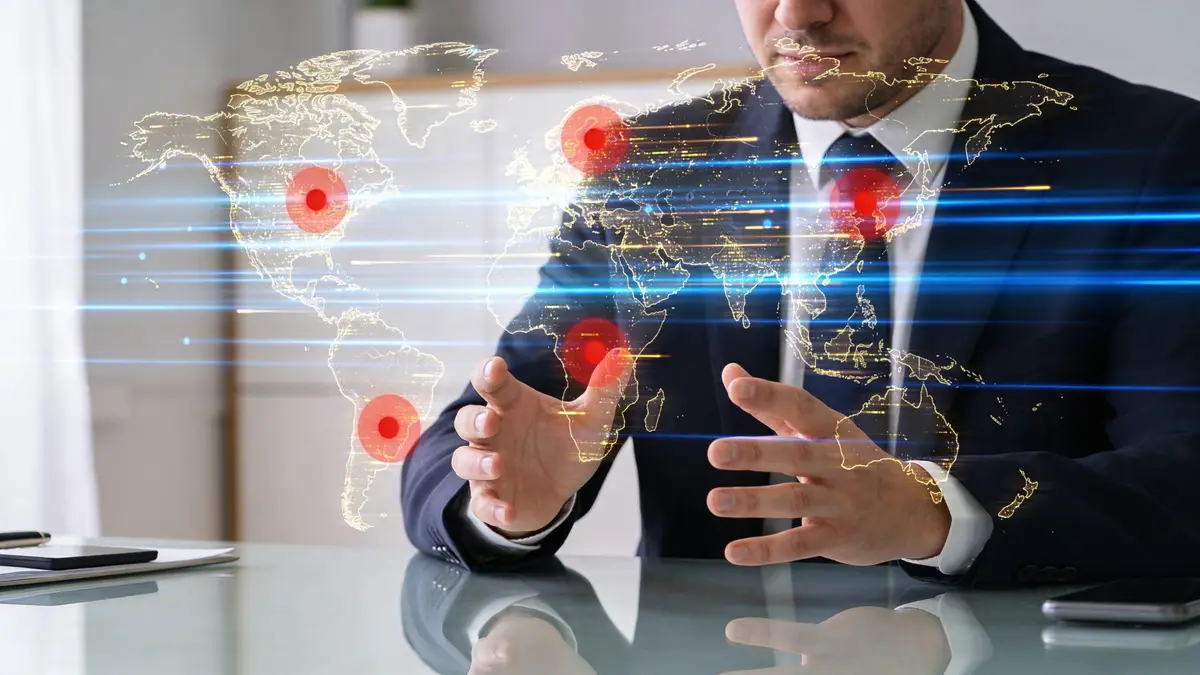 A businessman in a suit gestures toward a glowing digital map of the world displaying global data connections.