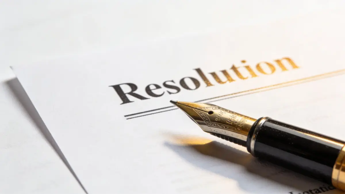 A close up view of a fountain pen resting on a document titled Resolution.